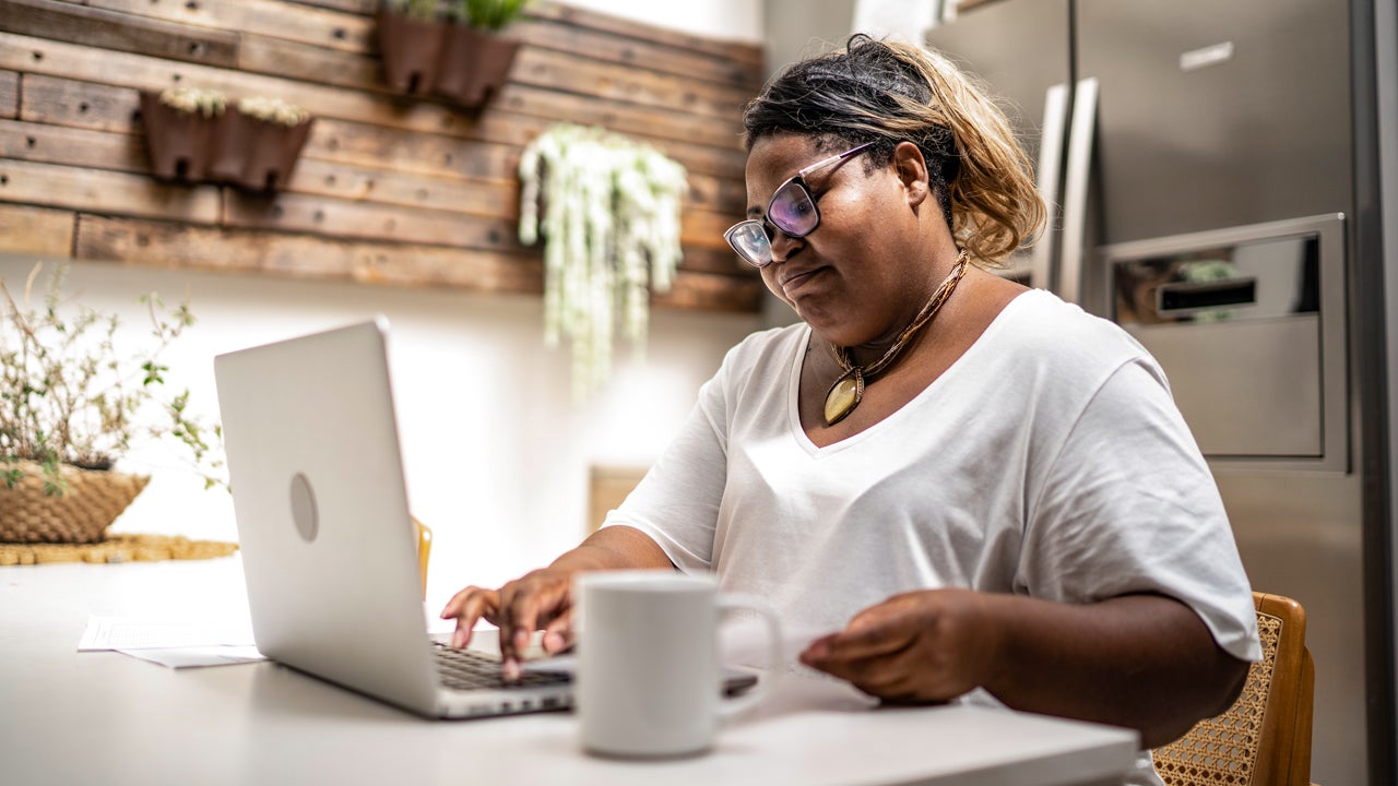 person working on laptop at the kitchen table