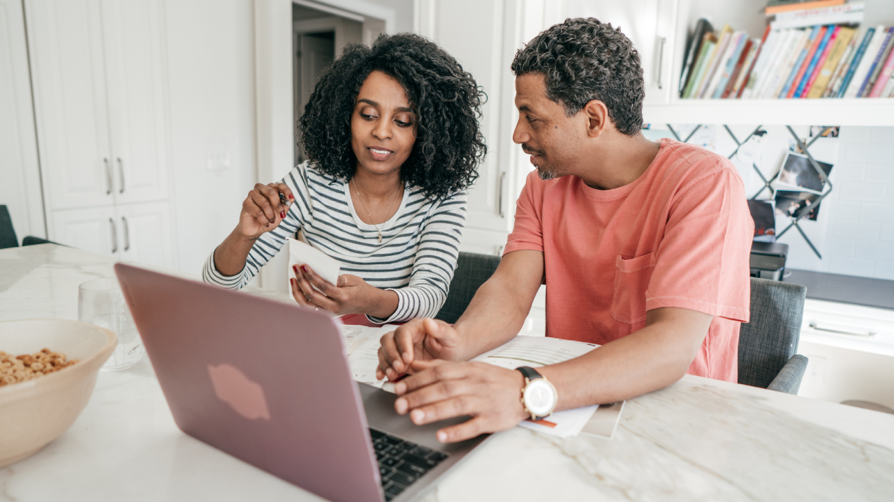 Couple and their financial planning in the kitchen with laptop