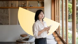 A young woman standing with her phone in her hands, looking off. There is an illustrated semicircle behind her.