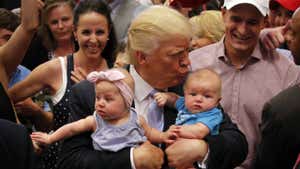 Donald Trump holding two babies.