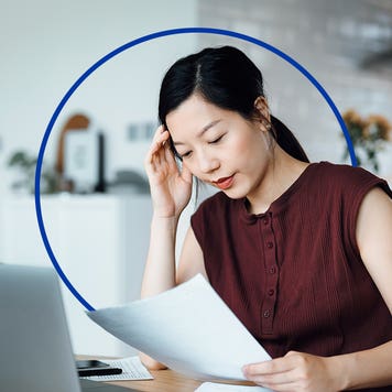 An Asian woman looks at paperwork